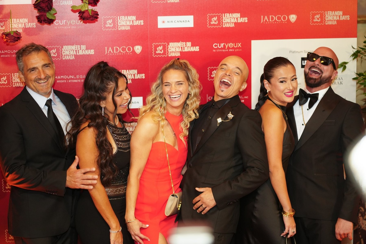 Guests photographed in front of the sponsor backdrop